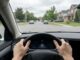 View from inside a car showing hands on the steering wheel while driving in Canada